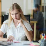 Frowning businesswoman looking at her laptop.